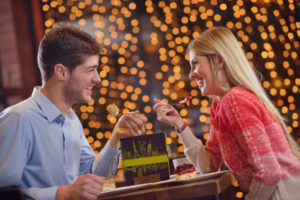 romantic evening date in restaurant happy young couple with wine glass tea and cake