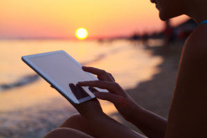 Woman using pad outdoor at sunset