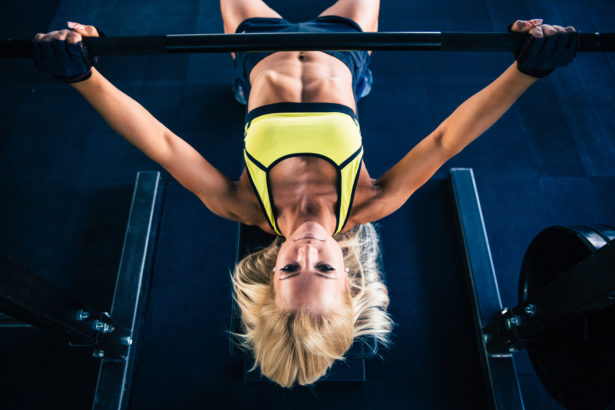 Woman workout with barbell on bench