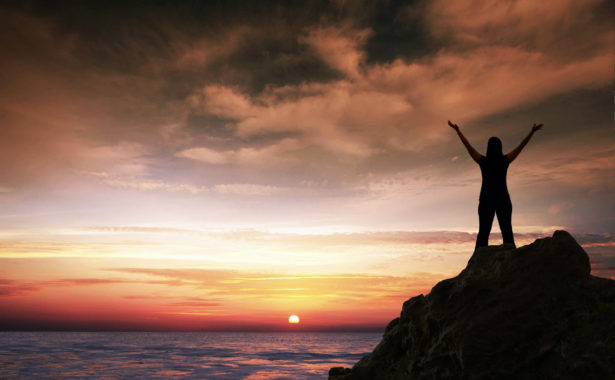 Woman in praise at sunrise