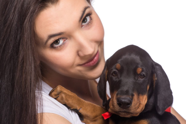 Brunette girl with her puppy isolated on white background