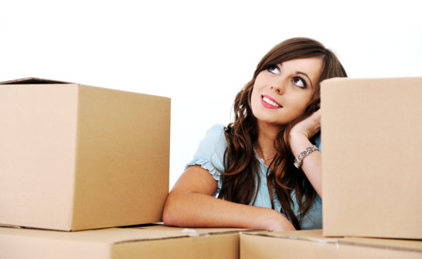 Cute young girl in a room with boxes for moving